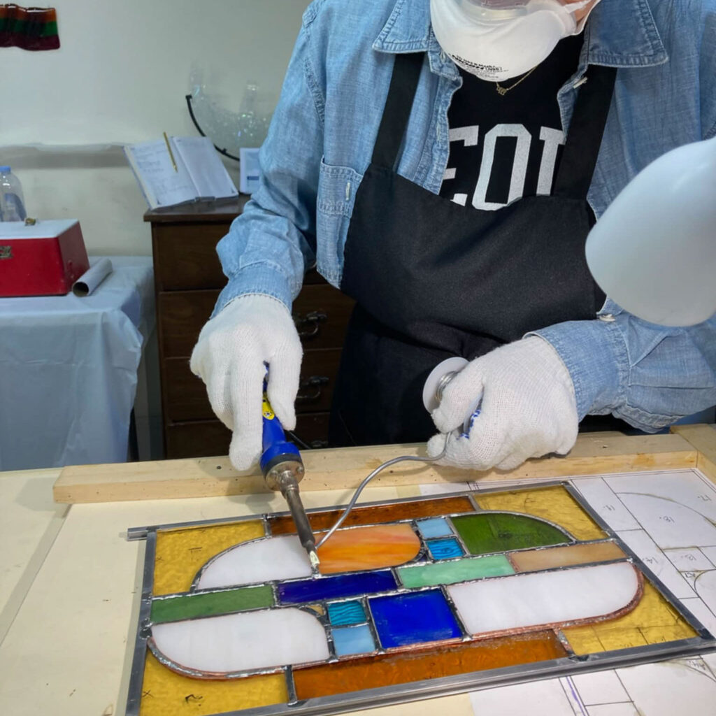 Hands-on stained glass class teaching soldering and glass cutting techniques for beginners