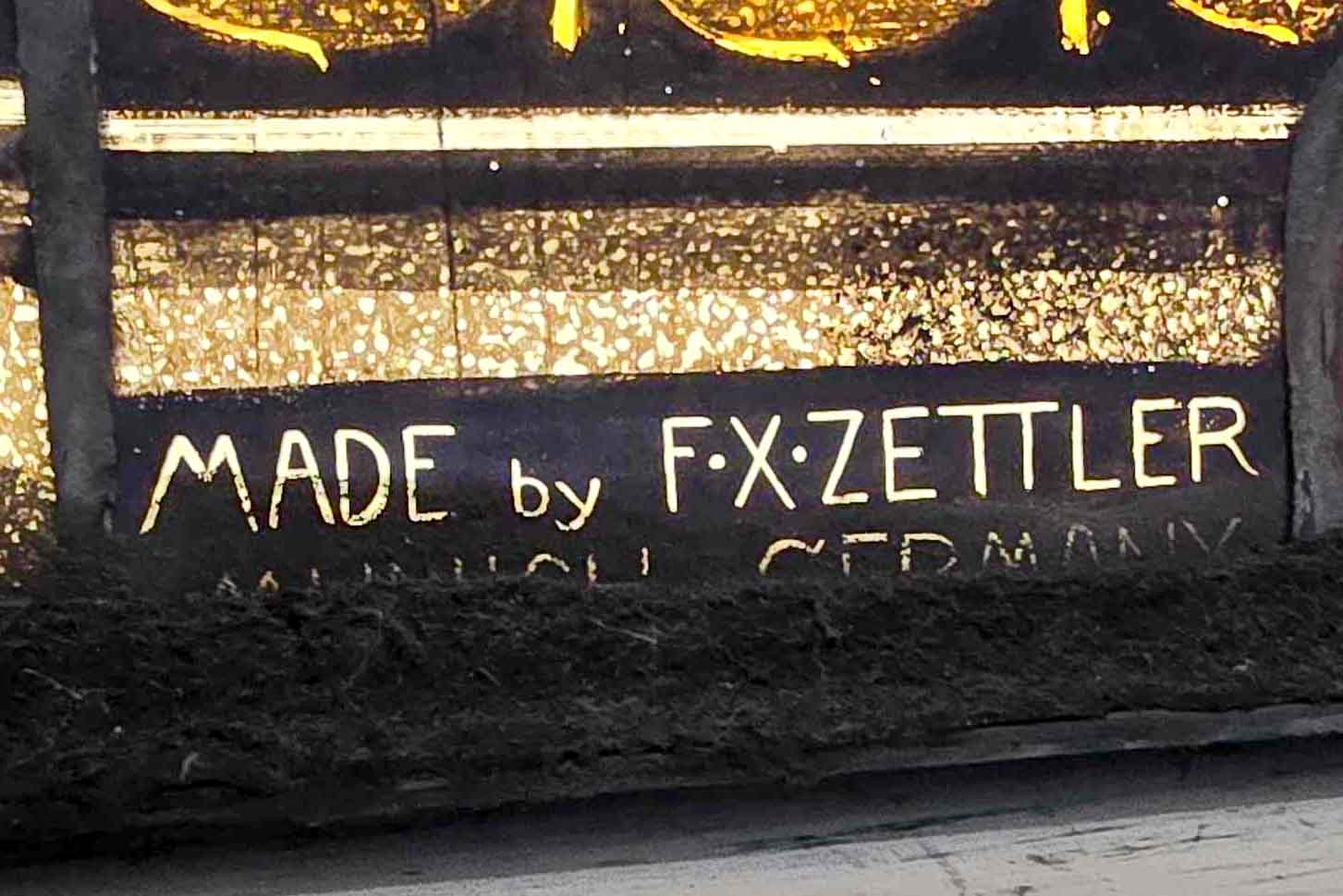 Maker’s mark reading Made by F. X. Zettler on historic stained glass window