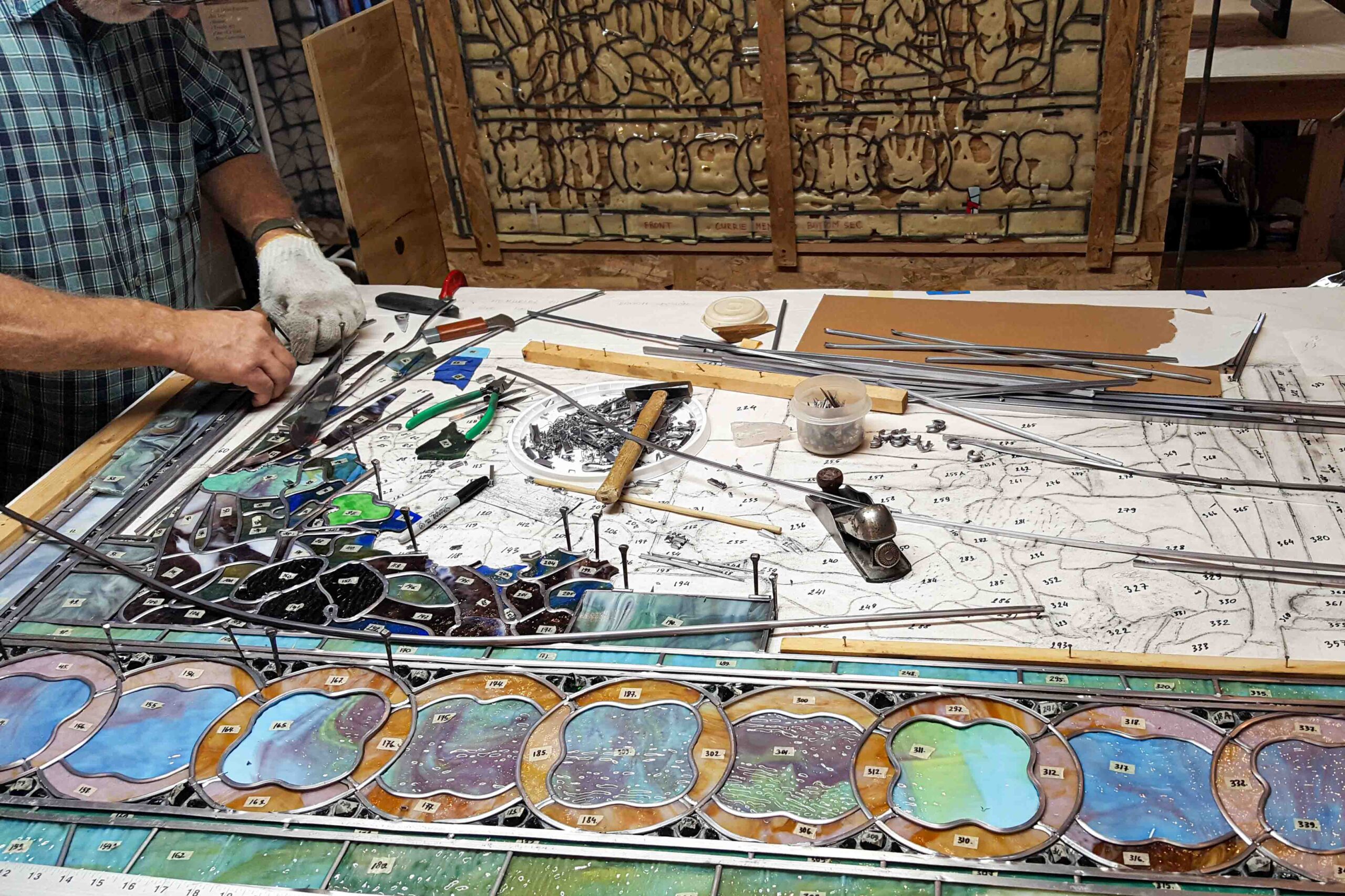 Baltic Art Studio conservator documenting stained glass repairs during Tiffany window restoration