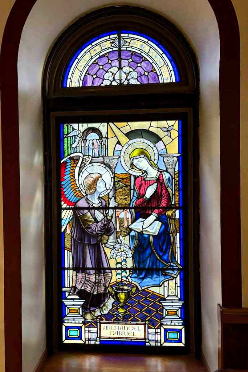 Stained glass artist Mindaugas Vitkauskas beside completed Archangel window at St. John Cantius Church